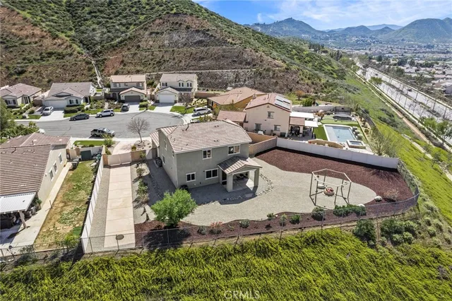 an aerial view of a house with a garden and mountain view