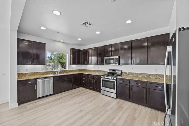 a large kitchen with stainless steel appliances granite countertop a stove and a sink