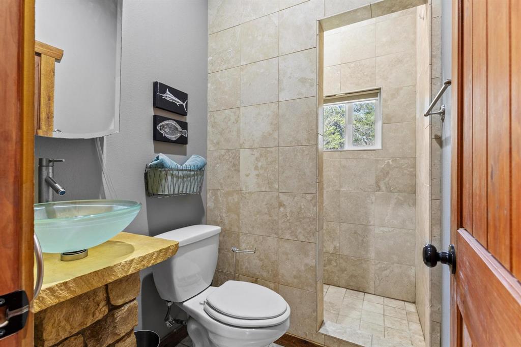 236 Homesite Road Pottsboro, TX 75076 - Photo 32 of 40 a bathroom with a toilet a sink and a shower