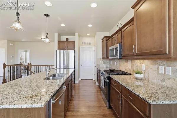 a kitchen with stainless steel appliances granite countertop a sink stove and refrigerator