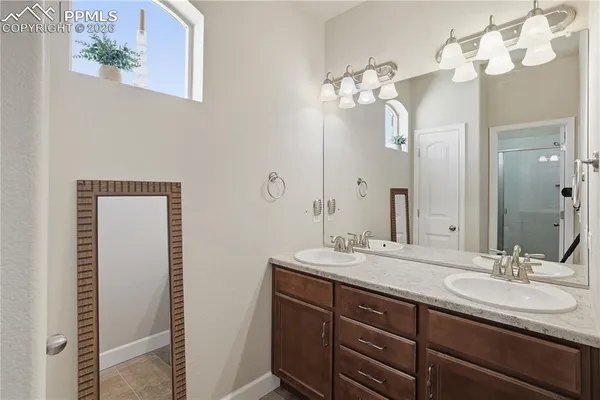 a bathroom with a double vanity sink and a mirror