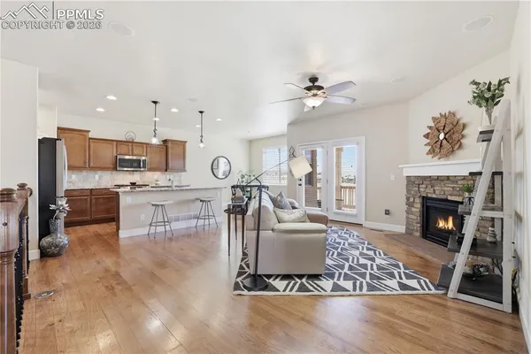 a living room with furniture a fireplace and kitchen view