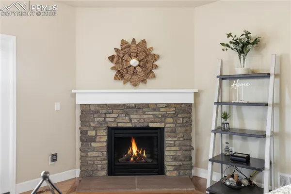 a living room with a fireplace and wooden floor