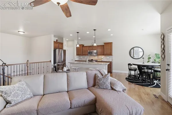 a living room with furniture kitchen view and a large window