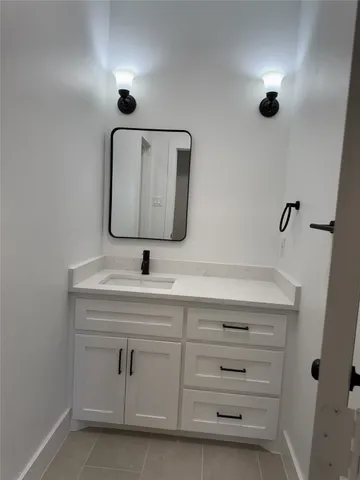 a bathroom with a sink vanity and mirror
