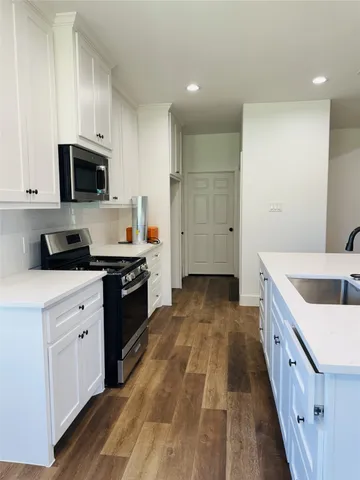 a kitchen with granite countertop a sink and a stove top oven