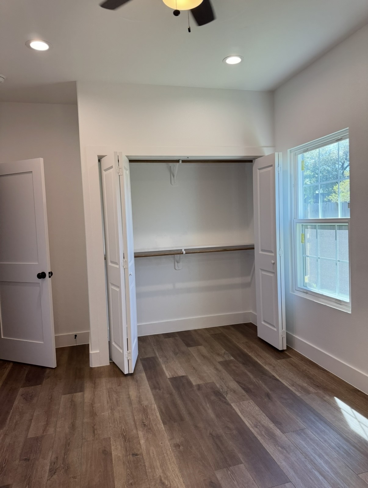 8437 Winthrop Lane Houston, TX 77075 - Photo 7 of 22 an empty room with wooden floor closet and windows