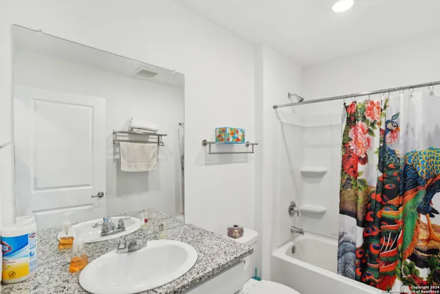 a bathroom with a sink toilet and shower