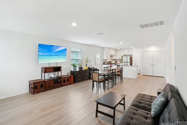 a living room with furniture and a dining table with kitchen view