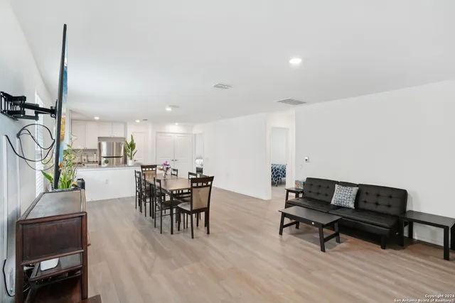 a living room with furniture a table and a kitchen view