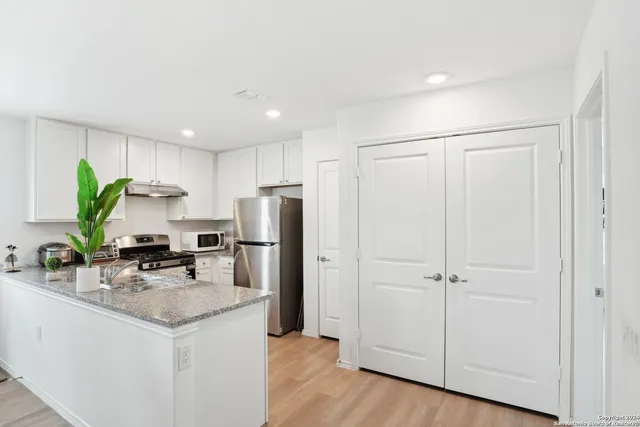 a kitchen with a refrigerator a sink and cabinets