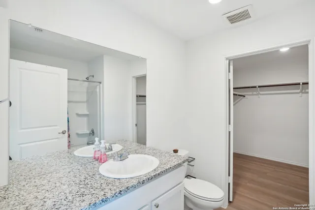 a bathroom with a granite countertop sink toilet and shower