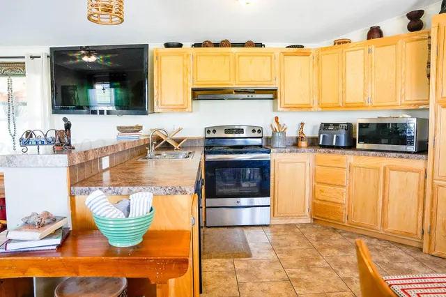 a kitchen with stainless steel appliances granite countertop a stove a sink and a microwave