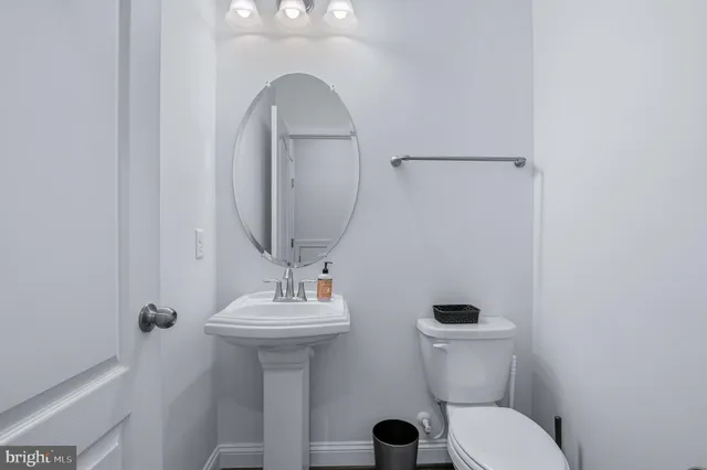 a bathroom with a toilet sink and mirror