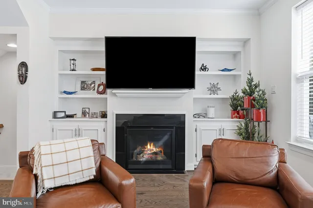 a living room with furniture a flat screen tv and a fireplace