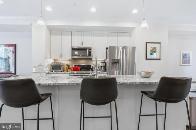 a living room with furniture and a view of kitchen