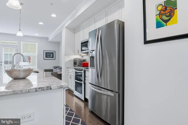 a kitchen with stainless steel appliances a stove a sink and a refrigerator