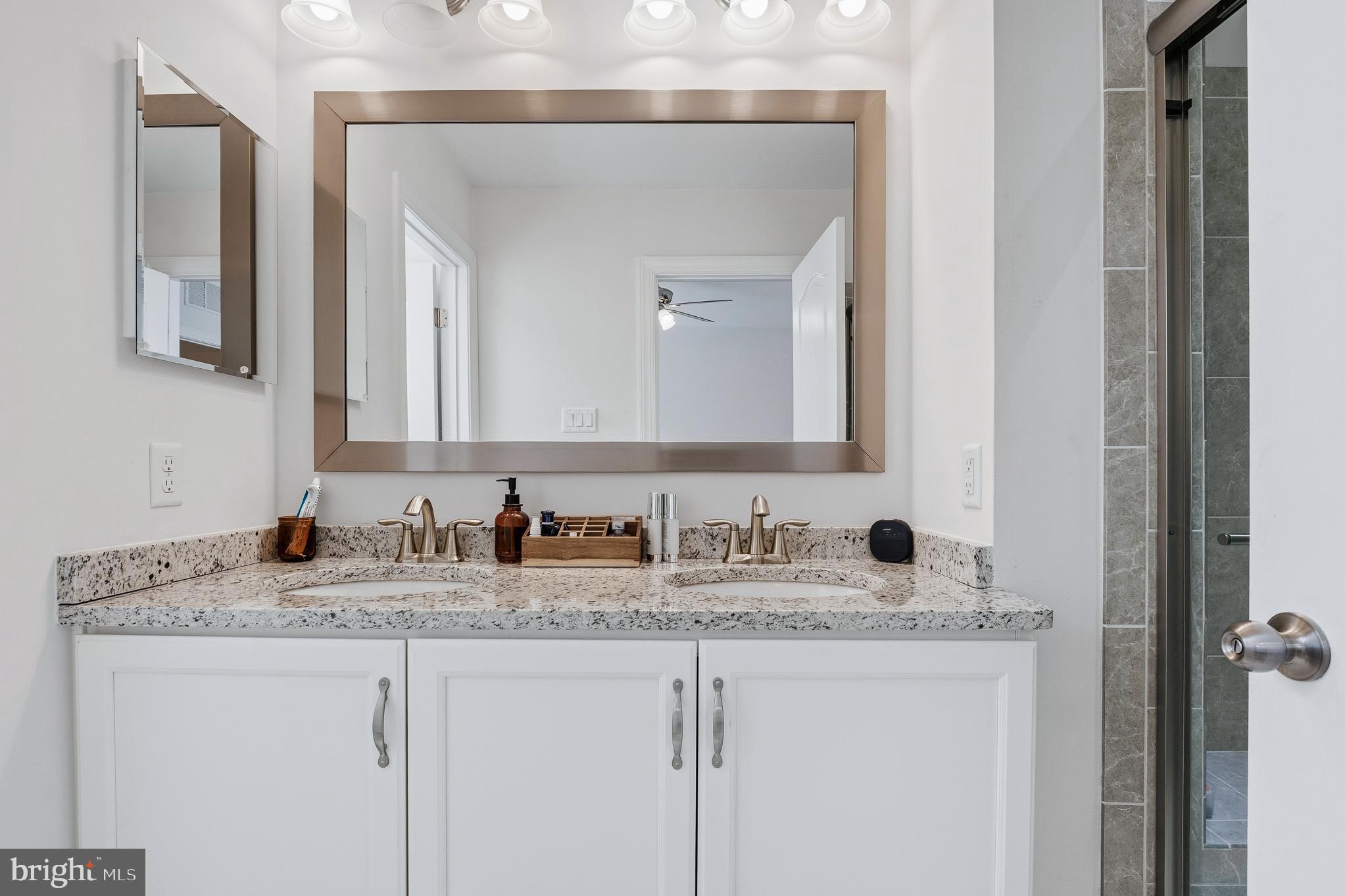 803 Francis Harris Place Annapolis, MD 21401 - Photo 27 of 52 a bathroom with a granite countertop sink and a mirror
