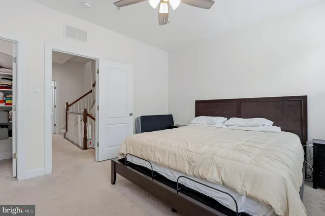 a bedroom with a bed and a flat tv screen on wall