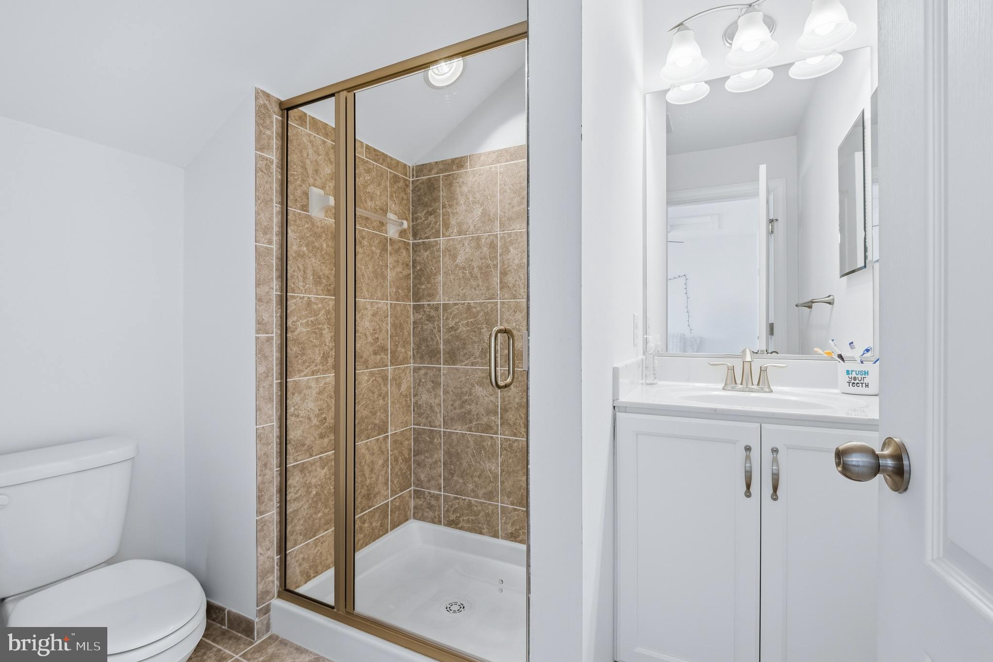803 Francis Harris Place Annapolis, MD 21401 - Photo 43 of 52 a bathroom with a shower a sink mirror and toilet