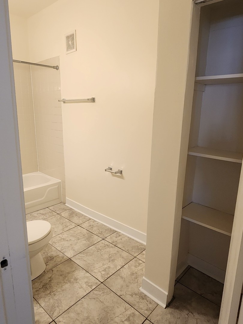 3219 West Division Street, Unit 2N Chicago, IL 60651 - Photo 13 of 14 a bathroom with a granite countertop shower and a toilet