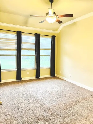 an empty room with windows and fan