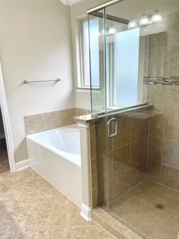 a bathroom with a granite countertop sink and a bathtub