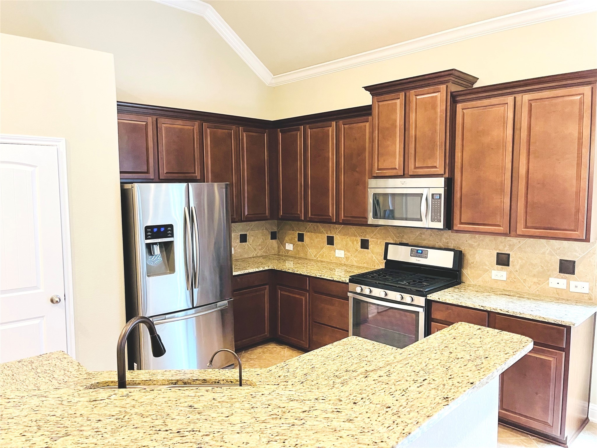 3430 Smart Sands Lane Fulshear, TX 77441 - Photo 7 of 25 a kitchen with stainless steel appliances granite countertop a refrigerator a sink and a stove