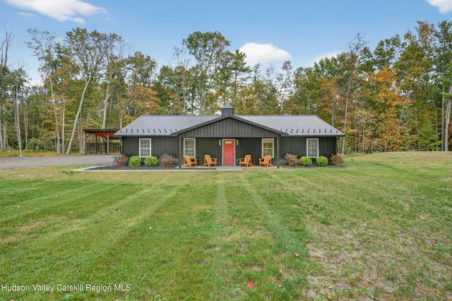 a front view of a house with yard and green space