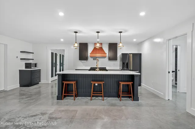 a kitchen with stainless steel appliances granite countertop a stove a sink and a refrigerator