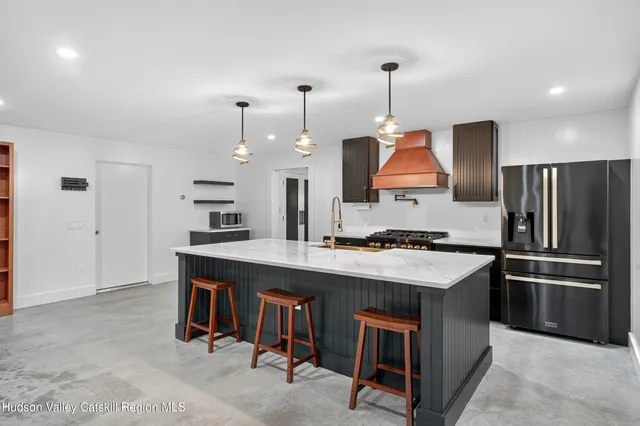 a kitchen that has a kitchen island wooden cabinets and stainless steel appliances