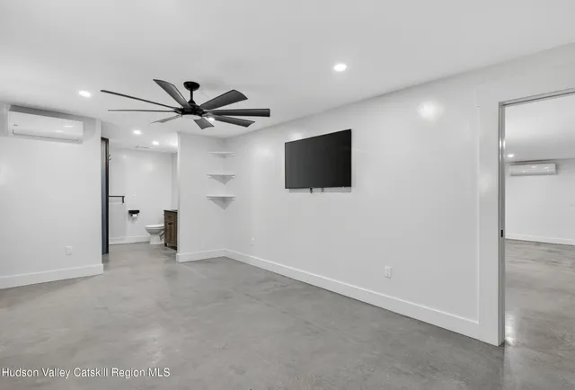 a view of a livingroom with a flat screen tv ceiling fan and a ceiling fan