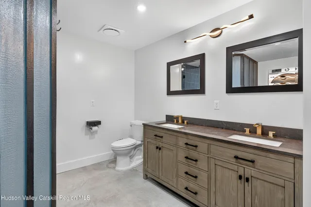 a bathroom with a toilet sink and mirror