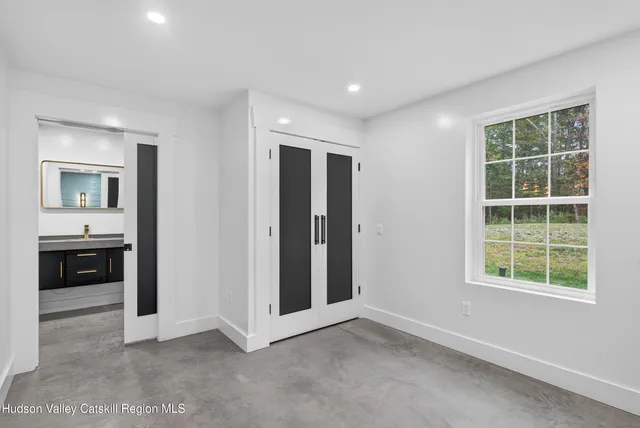 an empty room with a window and a kitchen