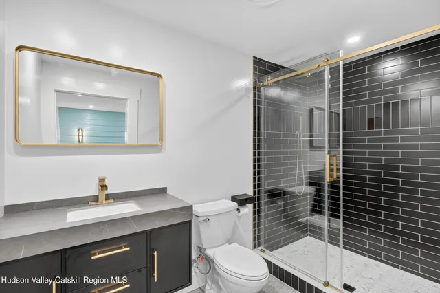 a bathroom with a toilet sink vanity and mirror