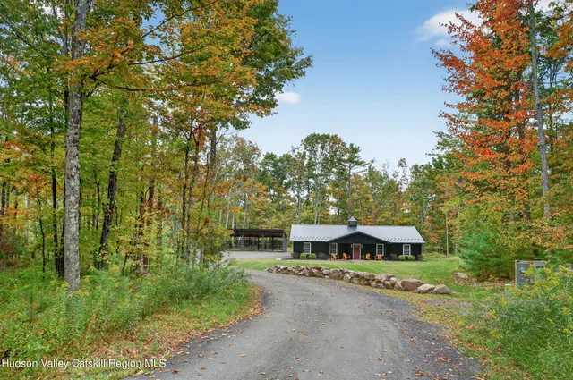a front view of a house with a yard and large trees