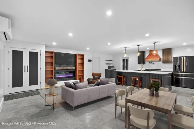 a living room with furniture kitchen view and a large window