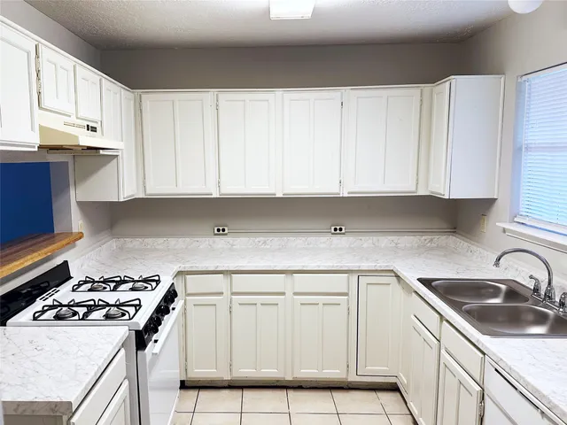 a kitchen with white cabinets sink and white appliances