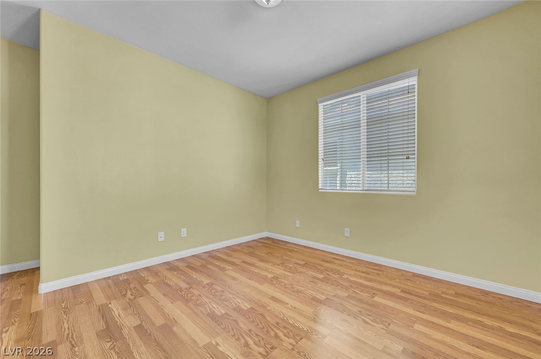 977 Sparkling Light Street Henderson, NV 89052 - Photo 51 of 75 This bright and airy room features gleaming hardwood floors and a large window, creating a serene atmosphere.