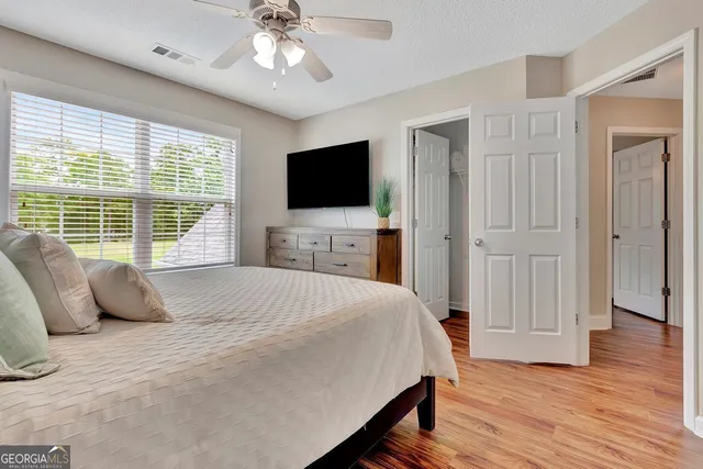 a bedroom with a bed and a flat tv screen on the dresser