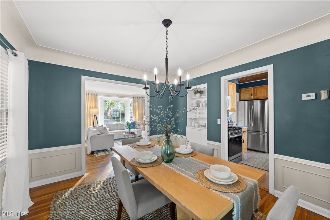 3690 Daleford Road Cleveland, OH 44120 - Photo 10 of 45 Dining area with wainscoting, dark wood finished floors, a chandelier, and a decorative wall