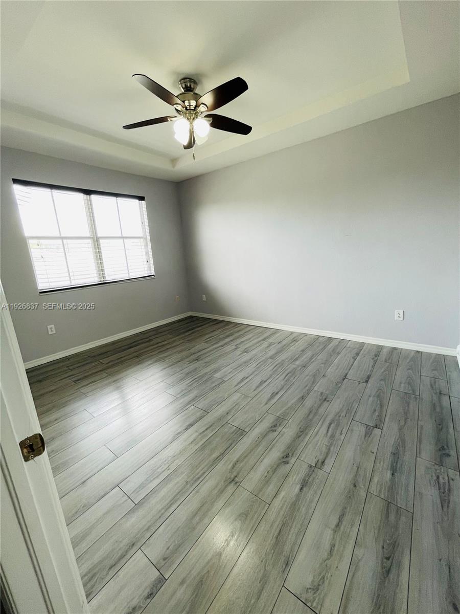 27312 Southwest 138th Path Homestead, FL 33032 - Photo 19 of 41 an empty room with wooden floor fan and windows