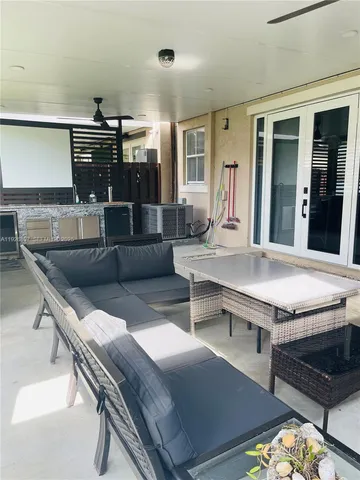 a living room with stainless steel appliances kitchen island granite countertop a stove and a sink