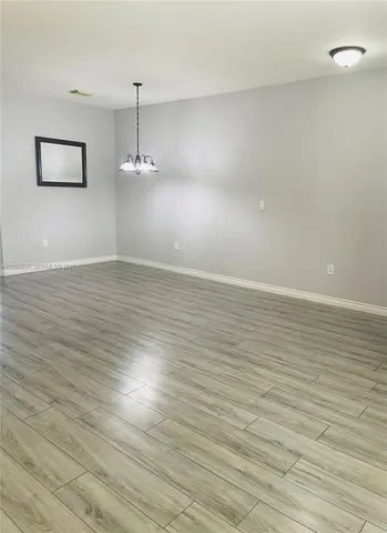 a view of a room with wooden floor and white walls