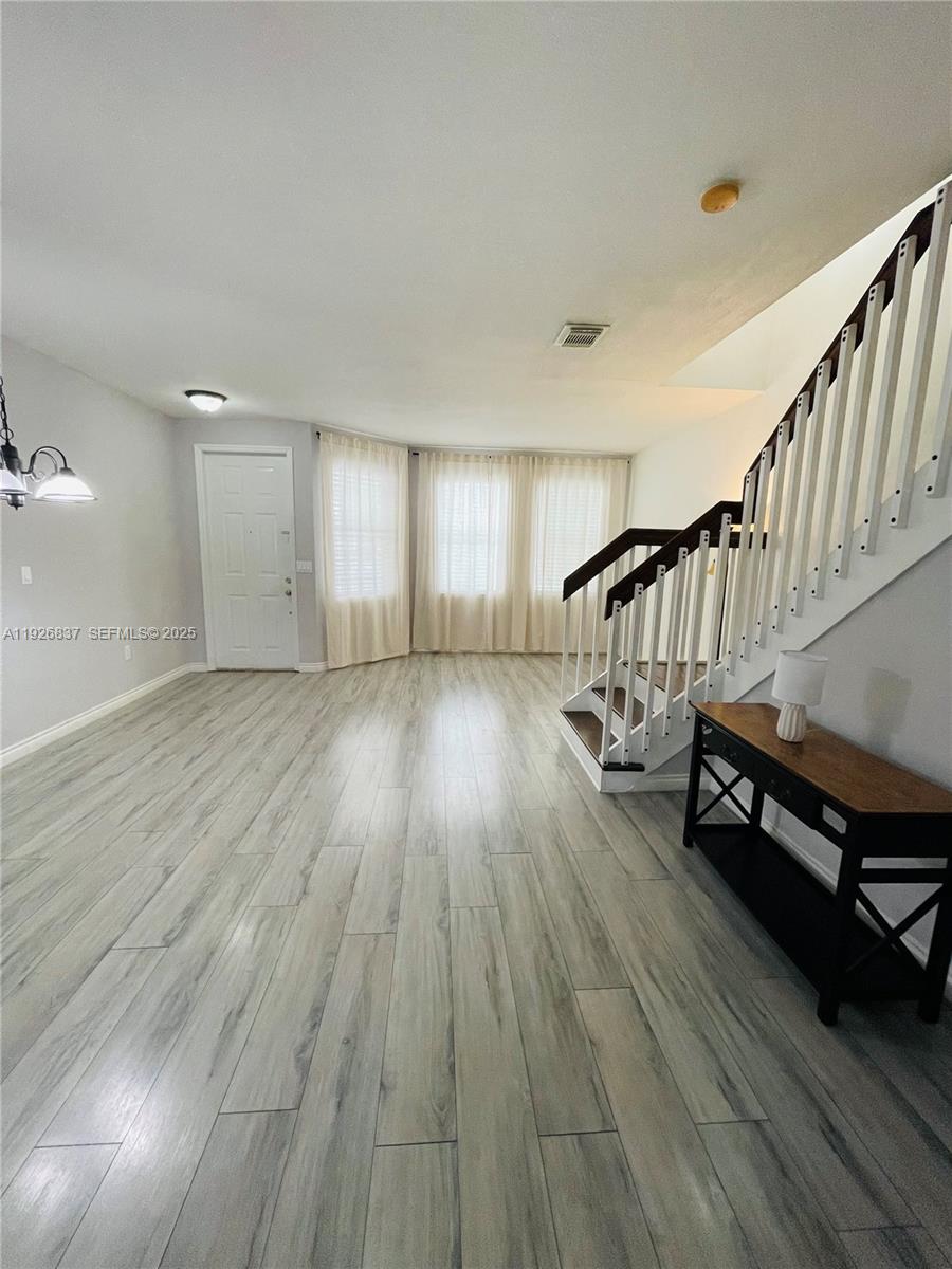 27312 Southwest 138th Path Homestead, FL 33032 - Photo 5 of 41 a view of an empty room with wooden floor and stairs