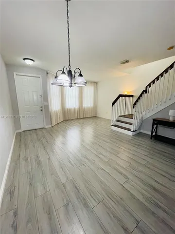 a view of a room with wooden floor and window