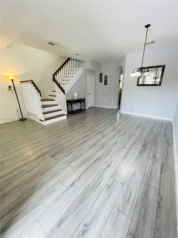 a view of a room with wooden floor and stairs