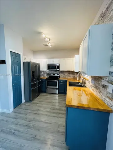 a large kitchen with a stove a refrigerator and a sink