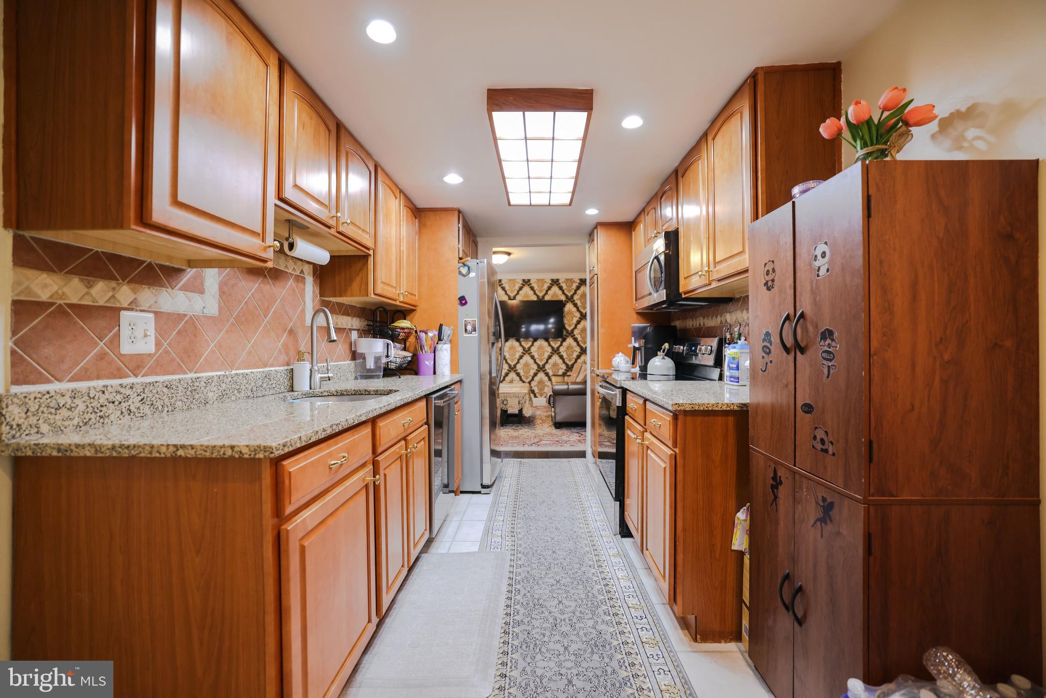 103 Garrison Court Langhorne, PA 19047 - Photo 11 of 46 a kitchen with stainless steel appliances granite countertop a sink a stove and a refrigerator