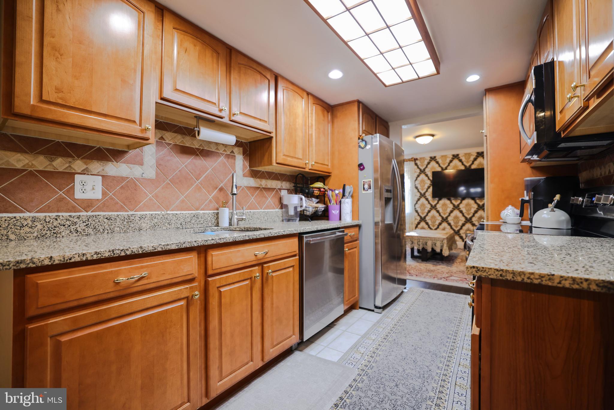 103 Garrison Court Langhorne, PA 19047 - Photo 12 of 46 a kitchen with stainless steel appliances granite countertop a sink stove and cabinets